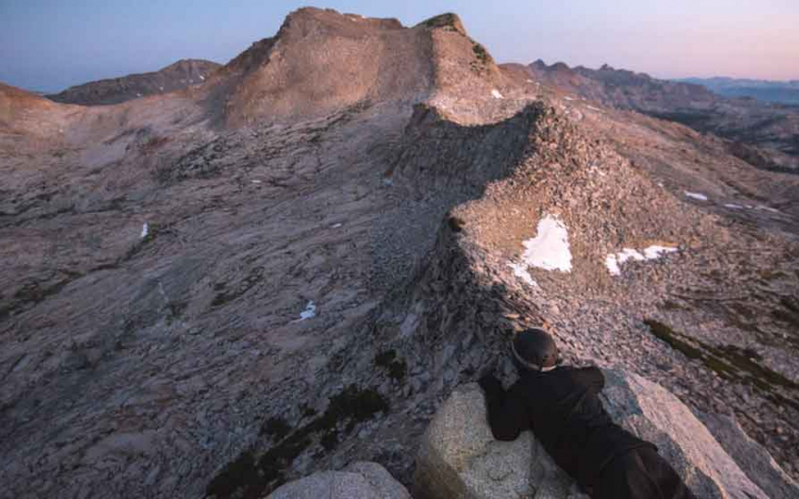 A mountainous ridge appears under pink and purple skies in California's Sierra Nevada Range. 